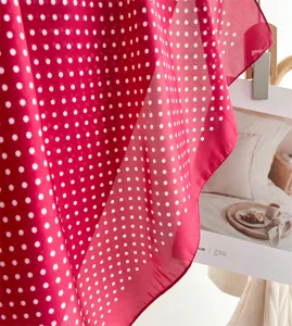 Dettaglio primo piano foulard seta pois rosso e bianco, elegante sfondo di oggetti di scena per donna.