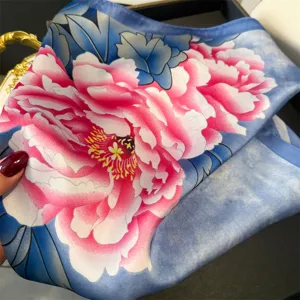 Exquisite silk square scarf with vibrant pink peony flowers on a blue background, soft and elegant.