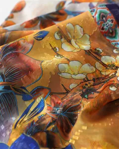 Detailed shot of a colorful floral printed silk scarf, lightweight shawl for women spring sun.