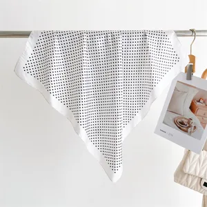Vista dettagliata del foulard classico a pois bianchi e neri, che mostra la sua trama.