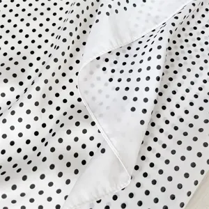 Vista ravvicinata e dettagliata della struttura del foulard in seta a pois bianchi e neri