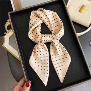 Vista dettagliata di un elegante foulard quadrato in seta con pois, classico accessorio.