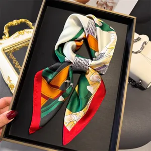 Detailed view of luxury silk scarf with harness print and vibrant red border, elegant accessory.