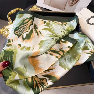 Close-up of green floral silk scarf, elegant printed square shawl for women styling details.