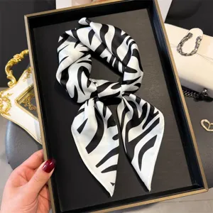 Gedetailleerd overzicht van zwart-witte zebra print zijden sjaal, elegante hals accessoire.