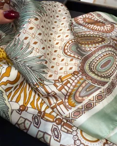 Close-up detail of luxurious silk scarf showcasing intricate geometric print and rich patterns.