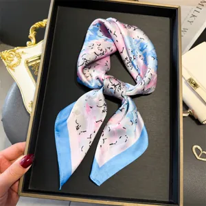 Vue détaillée d'un foulard en soie rose et bleu à imprimé abstrait, accessoire chic.