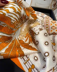 Exquisite silk scarf detail showing orange tropical leaf print and leopard pattern.