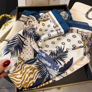 Elegant printed silk square scarf featuring chic chain and palm leaf patterns, versatile design.