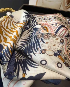 Luxurious printed silk square scarf featuring elegant chain and feather motifs for women.