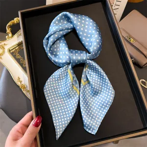 Detailansicht eines blauen Seidentuchs mit Punkten, elegantes Halstuch mit feinem gelben Rand.