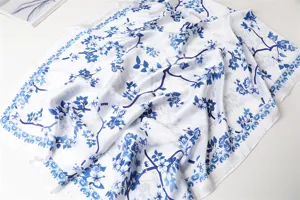 Elegant white silk scarf featuring blue floral branch print, versatile fashion shawl for women.