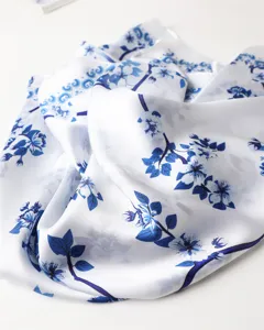Close-up detail of a soft imitation silk scarf featuring elegant blue floral print design.