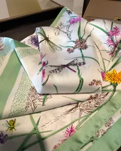 Detailed shot of the botanical dragonfly print silk scarf, showcasing the delicate fabric texture.