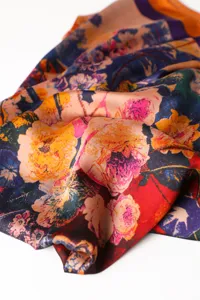Close-up detail of a vibrant floral print imitation silk scarf, showcasing rich colorful patterns.