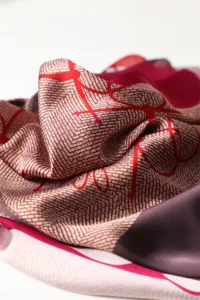 Close-up detail of the printed silk scarf showing fine geometric pattern and smooth fabric texture.