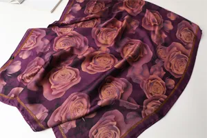 Detailed view of a purple silk scarf with elegant rose floral print and smooth texture.