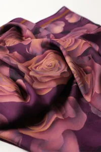 Elegant purple silk scarf with romantic pink rose floral print, smooth luxurious fabric.