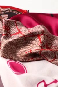 Detailed shot of luxurious silk scarf featuring classic equestrian and chain prints, elegant.