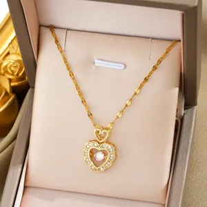 Gold-tone double heart pendant necklace with shimmering pink center stone and delicate chain.