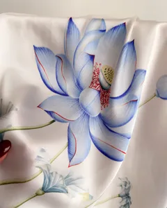 Close-up detail of white imitation silk square scarf featuring elegant blue lotus floral print.