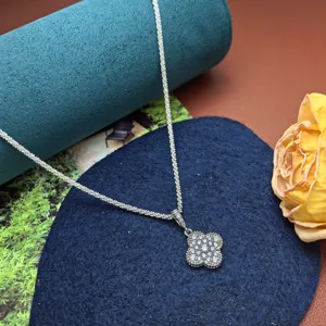 Silver four-leaf clover pendant necklace with sparkling stones and delicate twisted chain design.