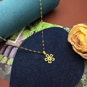 Detail view of gold titanium steel six-petal flower pendant necklace, delicate clavicle chain.