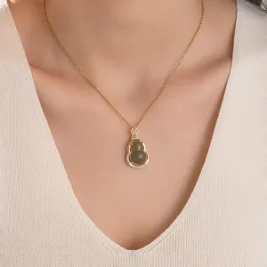 Detailed close-up view of a gold titanium steel necklace with a green gourd pendant.