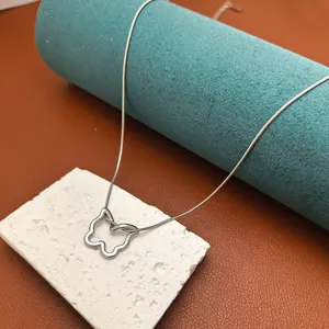 Hollow butterfly necklace detail shot, silver snake chain and pendant, trendy aesthetic jewelry.