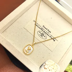 Exquisite gold necklace featuring a rectangular white shell pendant with a chic rose motif.