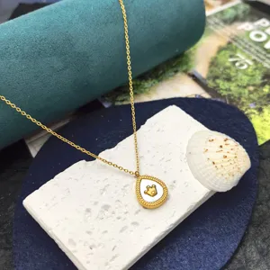 Detailed view of cute teardrop white shell crown pendant necklace, elegant gold chain jewelry.