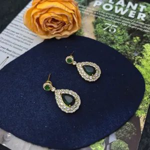 Detail view of elegant green gemstone and cubic zirconia drop earrings, luxury jewelry.