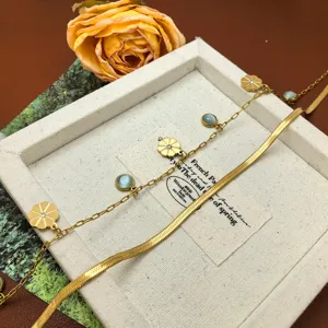 Minimalist layered titanium steel necklace featuring delicate flower and blue stone charms.