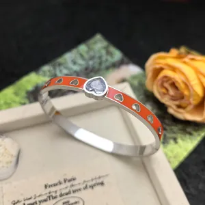 Orange enamel heart titanium steel bracelet detail, featuring sparkling crystal stone and cutout design.