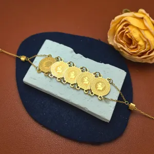 Close-up detail view of retro coin pendant gold bracelet, vintage style fashion jewelry.