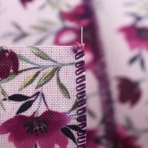 Close-up detail of purple-red floral wired ribbon with overlocked edge for gift wrapping decor.