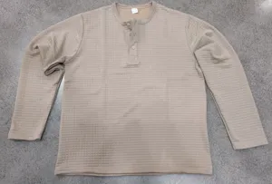 Detailed view of men khaki waffle knit long sleeve henley shirt, casual textured fabric.
