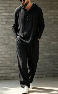 Detail shot of men's casual black linen hooded henley shirt and loose trousers set.