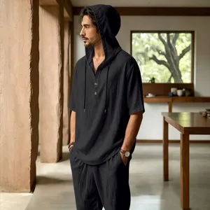 Details of men's casual linen hooded short sleeve shirt and trousers set in indoor scene.