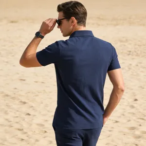 Detail view of men's solid blue summer short sleeve casual shirt in beach setting.