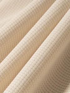 Dettaglio della trama del tessuto in maglia waffle beige, primo piano macro traspirante