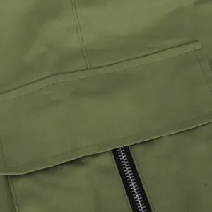 Primer plano detallado del tejido verde militar del pantalón cargo, textura sarga, bolsillo.