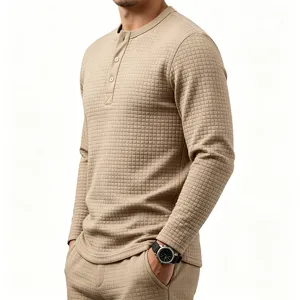 Close-up detail view of men's textured waffle knit long sleeve henley shirt in classic khaki.
