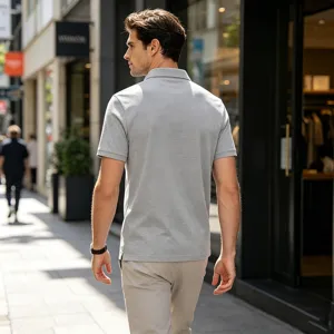 Vue détaillée du polo gris décontracté pour homme avec tissu respirant en milieu urbain extérieur.