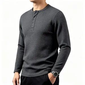 Detailed view of mens grey waffle knit long sleeve henley shirt with grid texture.