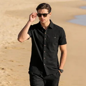 Detailed view of a casual black short sleeve linen blend shirt worn by a male model on beach.