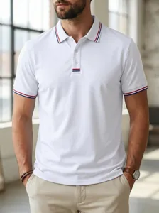 Close-up detail shot of mens casual white polo shirt with contrasting red and blue collar stripes.