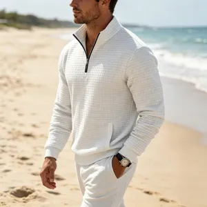 Men's waffle knit quarter-zip pullover sweatshirt in white, detailed view on beach.