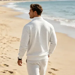Detailed view of men's white waffle knit quarter-zip pullover sweater texture and collar.