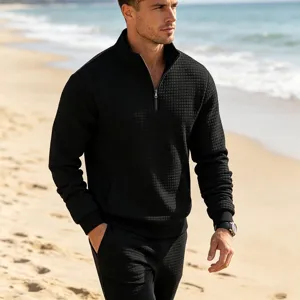 Men's black waffle-knit quarter-zip sweatshirt showing fabric texture and design detail.